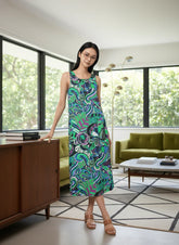 Bold and vibrant Nela dress by Blissfully Brand, featuring a retro-inspired, multicolored abstract swirl and floral pattern in greens, blues, and purples; sleeveless midi-length design perfect for making a statement for chic, retro fashion enthusiasts